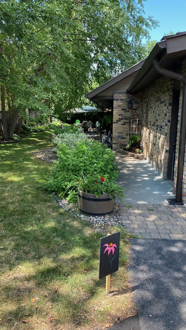 view of side of property featuring brick siding and a lawn