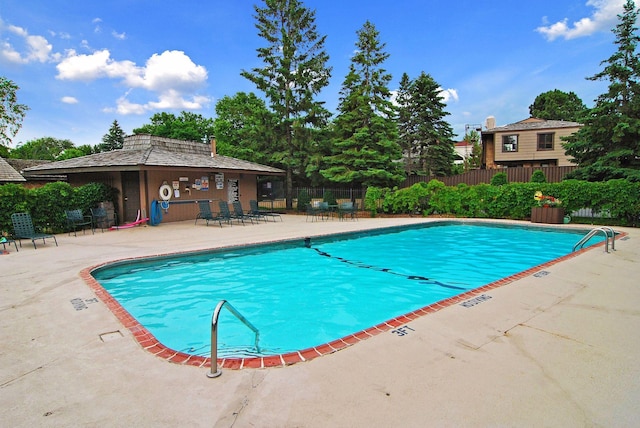 community pool featuring fence and a patio