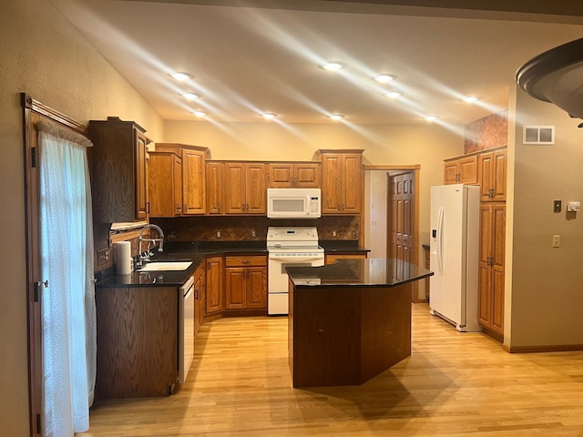10822 Steamboat Loop NW, Walker, MN 56484 - kitchen with white appliances, lofted ceiling, dark countertops, light wood finished floors, and tasteful backsplash