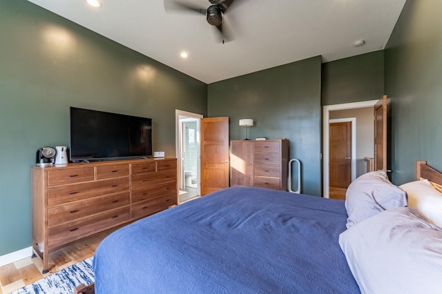 21107 Ghia St NE, East Bethel, MN 55011 - bedroom with a towering ceiling, light wood-type flooring, baseboards, ensuite bath, and ceiling fan
