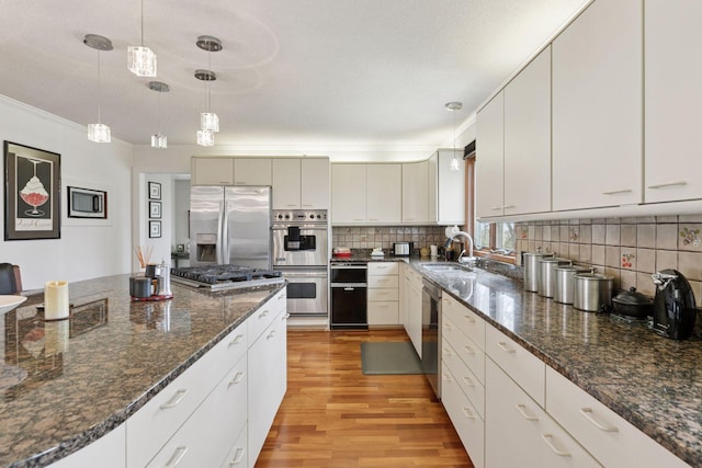 N7453 County Road Qq, Prescott, WI 54021 - kitchen with a sink, stainless steel appliances, light wood-type flooring, pendant lighting, and decorative backsplash