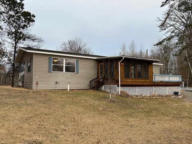 54966 Rainbow Rd, Sand Lake Twp, MN 56636 - view of front of property featuring a sunroom, a wooden deck, and a front lawn