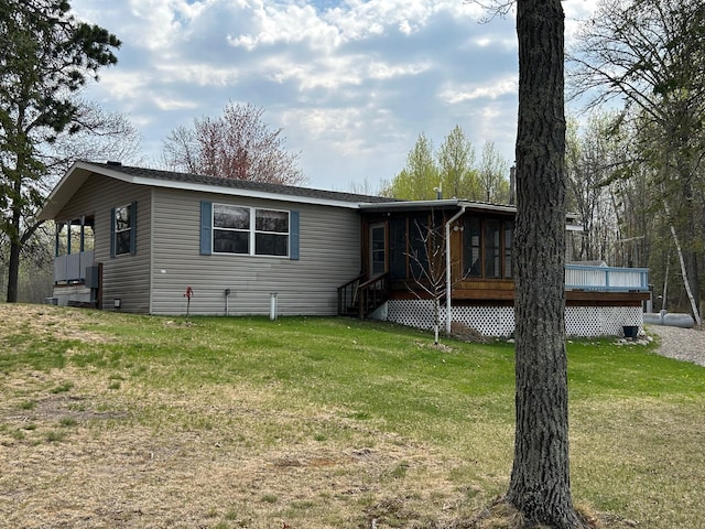 54966 Rainbow Rd, Sand Lake Twp, MN 56636 - manufactured / mobile home featuring a front yard, a wooden deck, and a sunroom