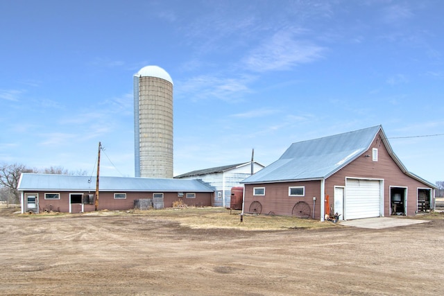 exterior space featuring driveway, a detached garage, and an outdoor structure