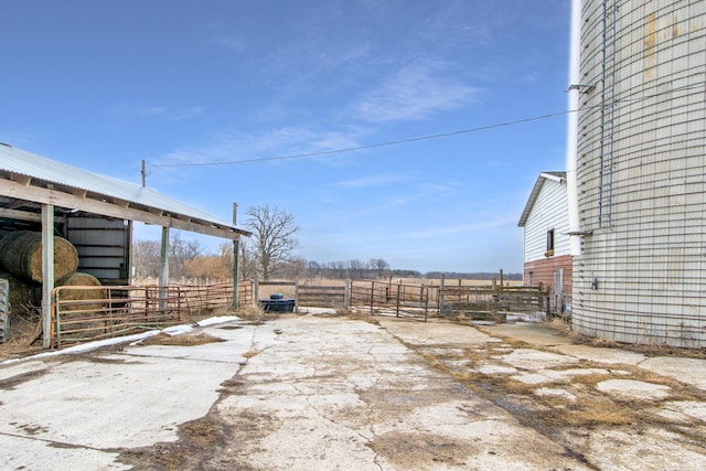 view of yard featuring an exterior structure, an outdoor structure, and a rural view