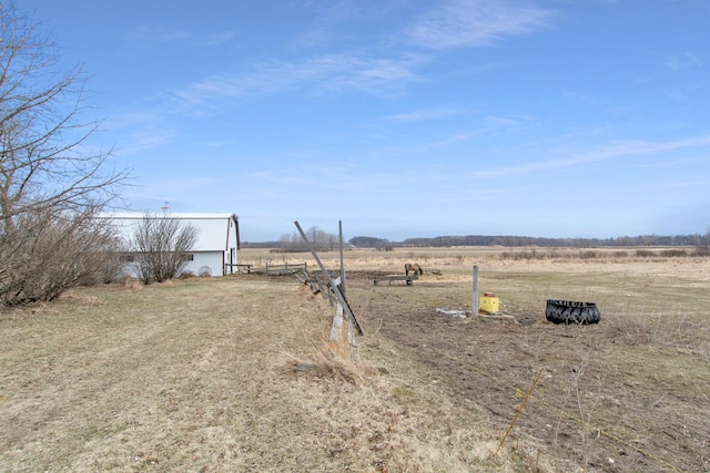 view of yard featuring a pole building, an outdoor structure, and a rural view
