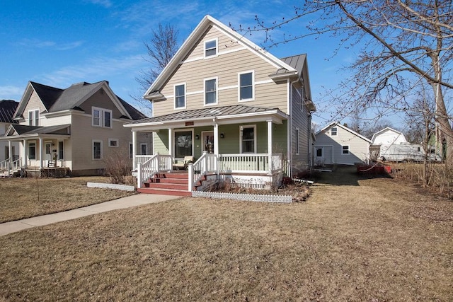 view of front of house featuring metal roof, a standing seam roof, a front yard, and covered porch