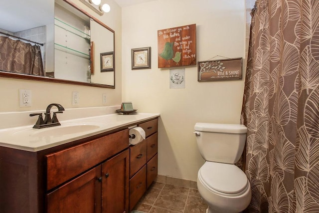 bathroom featuring toilet, tile patterned floors, vanity, and baseboards