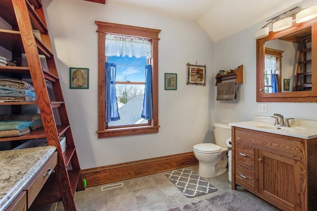 bathroom featuring toilet, vanity, baseboards, visible vents, and lofted ceiling