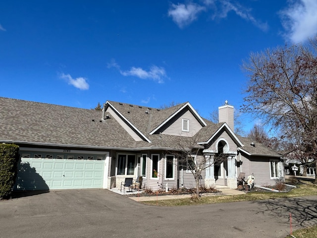 2548 Sumac Rdg, White Bear Lake, MN 55110 - view of front of home featuring roof with shingles, an attached garage, a chimney, and driveway