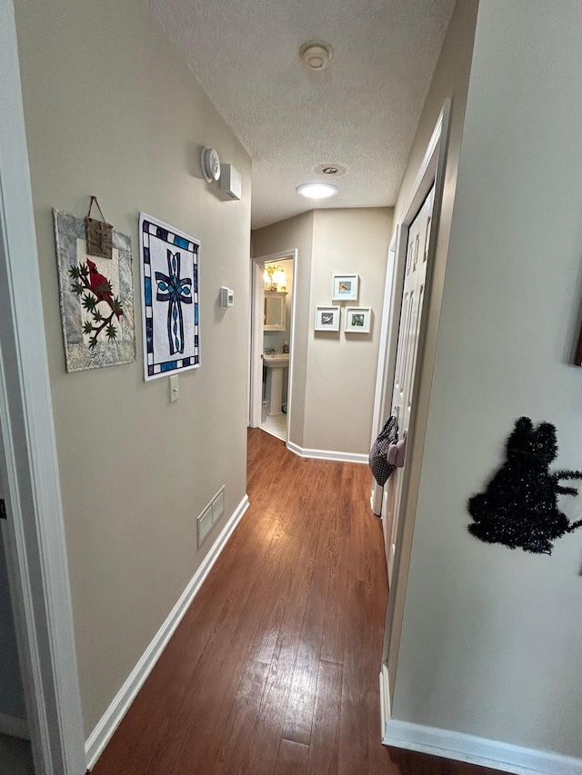 2548 Sumac Rdg, White Bear Lake, MN 55110 - hallway featuring baseboards, a textured ceiling, visible vents, and wood finished floors