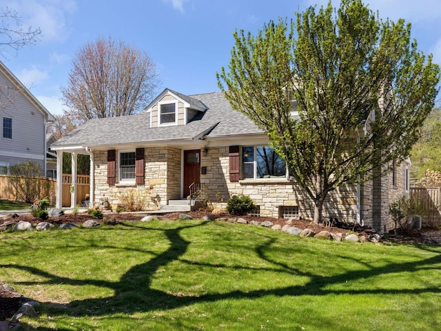 cape cod house featuring stone siding and roof with shingles