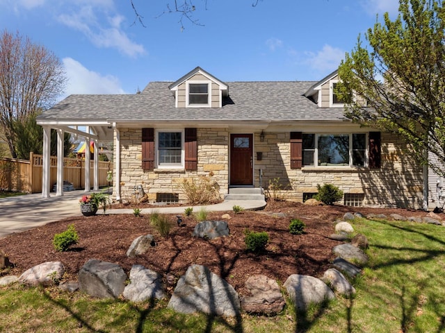 cape cod house with stone siding, fence, and a shingled roof