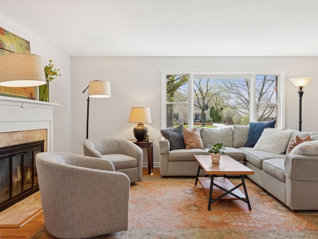 living room with a glass covered fireplace and light wood-style flooring