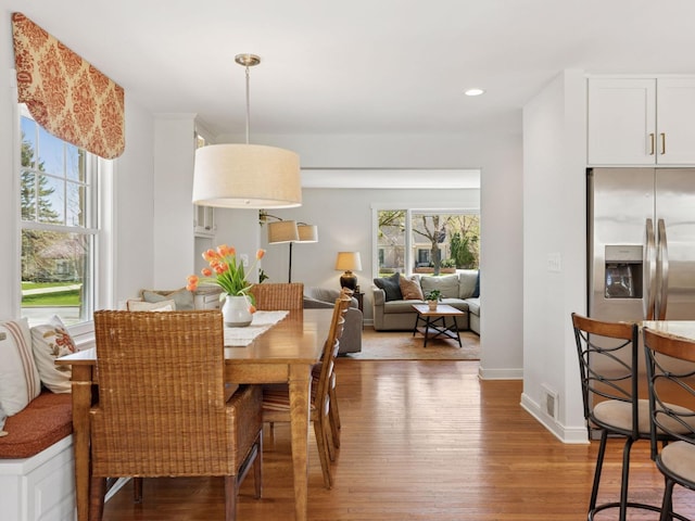 dining area with healthy amount of natural light, light wood finished floors, recessed lighting, and baseboards