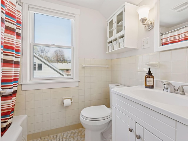full bathroom featuring tile walls, toilet, vanity, curtained shower, and tile patterned floors