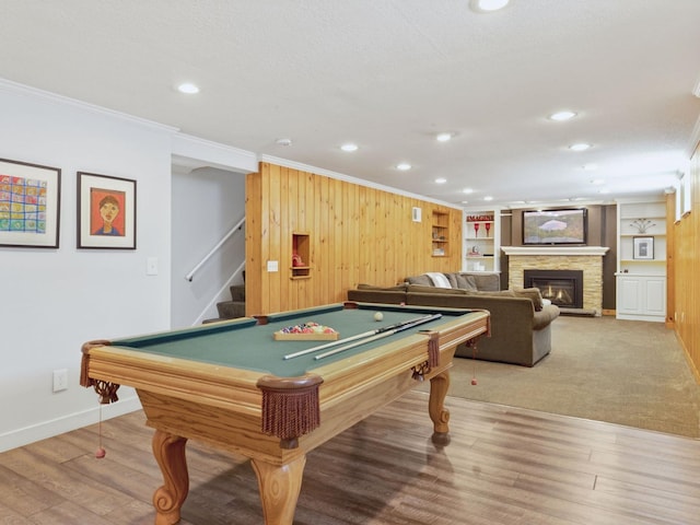 recreation room featuring crown molding, billiards, recessed lighting, a fireplace, and wooden walls