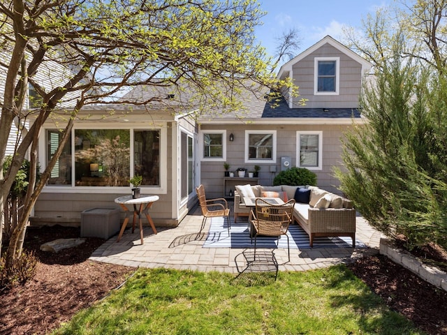 rear view of house featuring an outdoor hangout area, a patio area, and a shingled roof