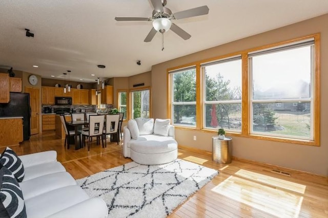11373 Balsam Way, Woodbury, MN 55129 - living area featuring wood finished floors, ceiling fan, visible vents, and recessed lighting