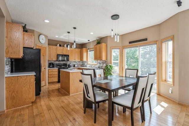 11373 Balsam Way, Woodbury, MN 55129 - dining space featuring a textured ceiling, light wood finished floors, plenty of natural light, and recessed lighting