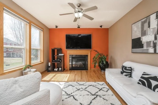 11373 Balsam Way, Woodbury, MN 55129 - living area with a fireplace with flush hearth, wood finished floors, and a ceiling fan