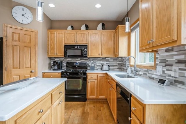 11373 Balsam Way, Woodbury, MN 55129 - kitchen with light countertops, black appliances, decorative backsplash, light wood finished floors, and a sink