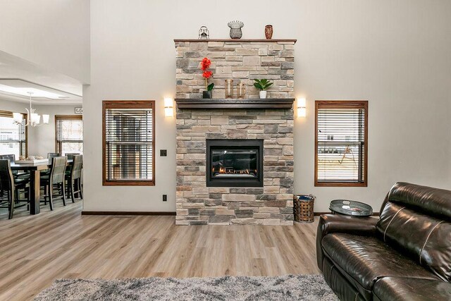 1408 72nd Ave S, Fargo, ND 58104 - living area with wood finished floors, a chandelier, a fireplace, and baseboards