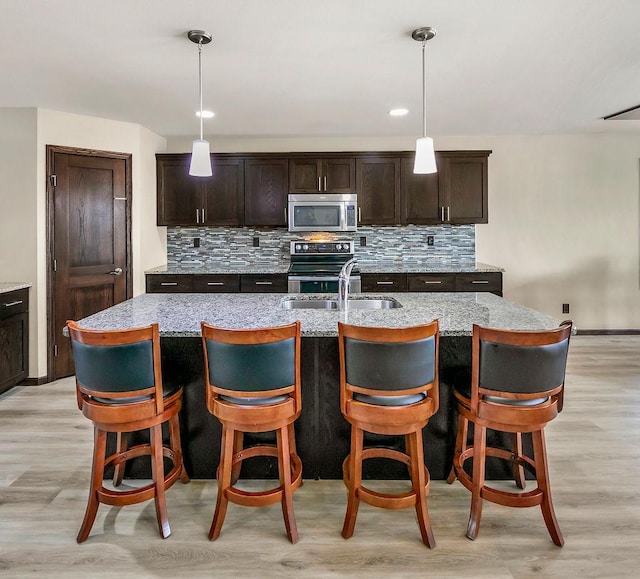 1408 72nd Ave S, Fargo, ND 58104 - kitchen with appliances with stainless steel finishes, a sink, backsplash, and light wood-style floors