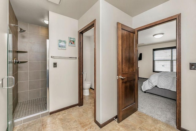 1408 72nd Ave S, Fargo, ND 58104 - ensuite bathroom featuring a stall shower, baseboards, and toilet
