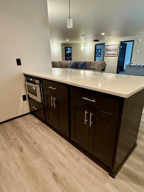 1408 72nd Ave S, Fargo, ND 58104 - kitchen with open floor plan, light wood finished floors, oven, light countertops, and dark brown cabinets