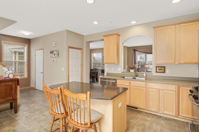 13775 54th Ave N, Plymouth, MN 55446 - kitchen featuring light brown cabinets, stainless steel dishwasher, arched walkways, a breakfast bar, and a kitchen island