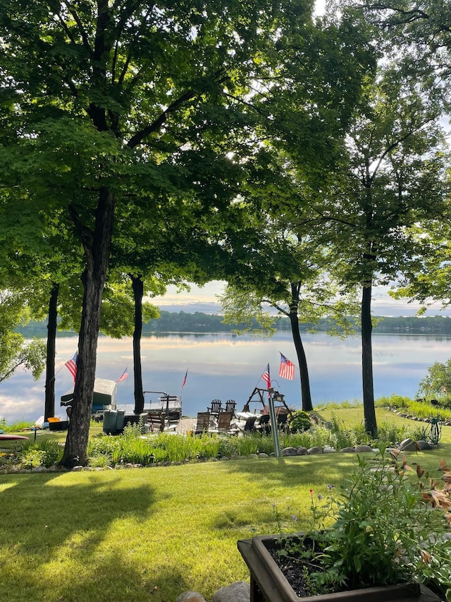 surrounding community featuring a lawn and a water view