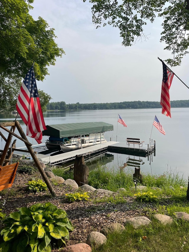 dock area featuring boat lift and a water view