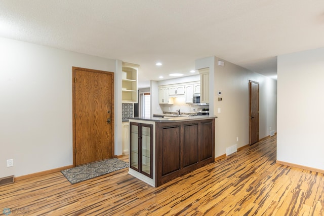 1611 32nd St S, Fargo, ND 58103 - kitchen featuring visible vents, light wood-style floors, stainless steel microwave, white cabinetry, and stove