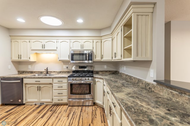 1611 32nd St S, Fargo, ND 58103 - kitchen featuring cream cabinetry, light wood-style floors, visible vents, stainless steel appliances, and a sink