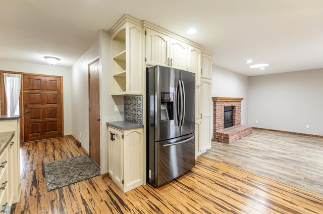 1611 32nd St S, Fargo, ND 58103 - kitchen featuring cream cabinetry, baseboards, light wood-type flooring, and stainless steel fridge