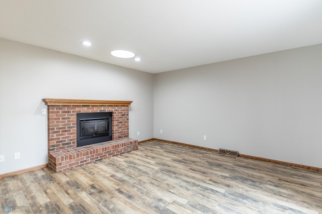 1611 32nd St S, Fargo, ND 58103 - unfurnished living room with a brick fireplace, recessed lighting, wood finished floors, and baseboards
