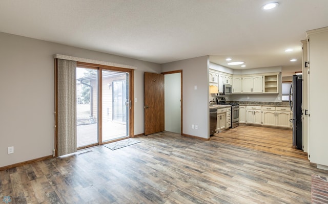 1611 32nd St S, Fargo, ND 58103 - kitchen with recessed lighting, light wood finished floors, baseboards, and appliances with stainless steel finishes