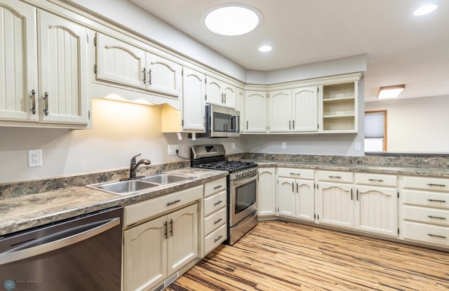 1611 32nd St S, Fargo, ND 58103 - kitchen with recessed lighting, light wood-style flooring, cream cabinetry, appliances with stainless steel finishes, and a sink