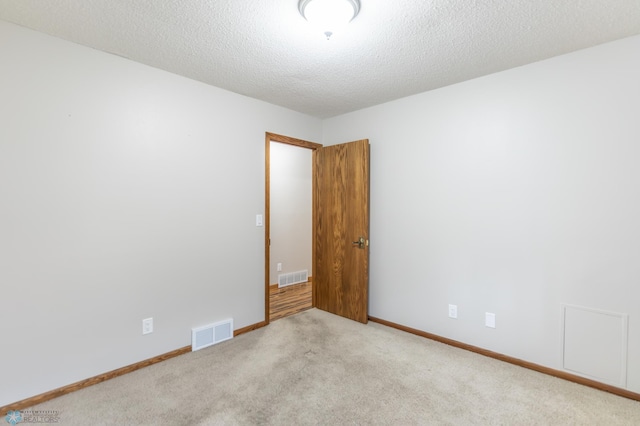 1611 32nd St S, Fargo, ND 58103 - spare room with visible vents, baseboards, carpet floors, and a textured ceiling