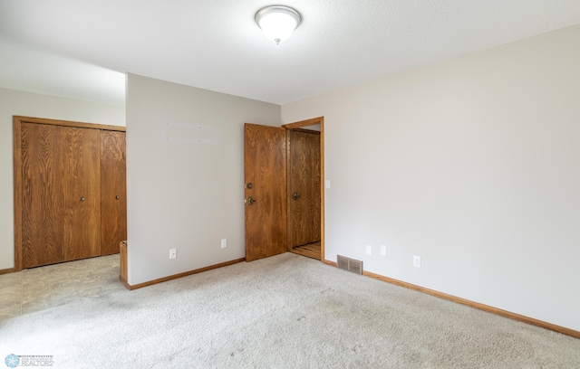 1611 32nd St S, Fargo, ND 58103 - unfurnished bedroom with visible vents, baseboards, a closet, and carpet floors