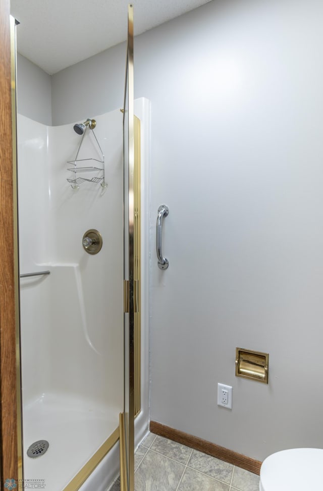 1611 32nd St S, Fargo, ND 58103 - full bath with a shower stall, tile patterned flooring, baseboards, and toilet