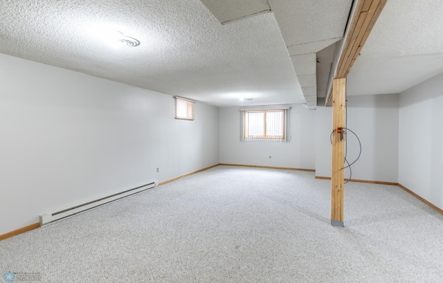1611 32nd St S, Fargo, ND 58103 - below grade area featuring baseboard heating, baseboards, a textured ceiling, and carpet floors