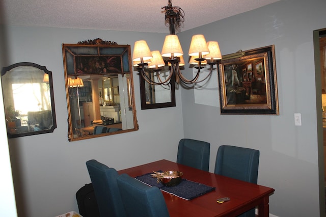 dining space with a textured ceiling and a notable chandelier