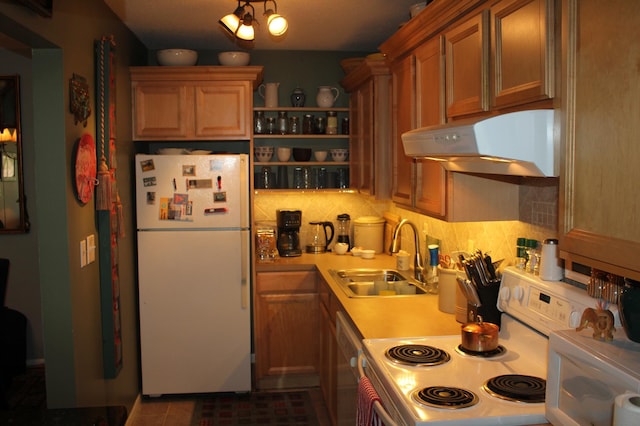 kitchen featuring a sink, white appliances, under cabinet range hood, light countertops, and tasteful backsplash