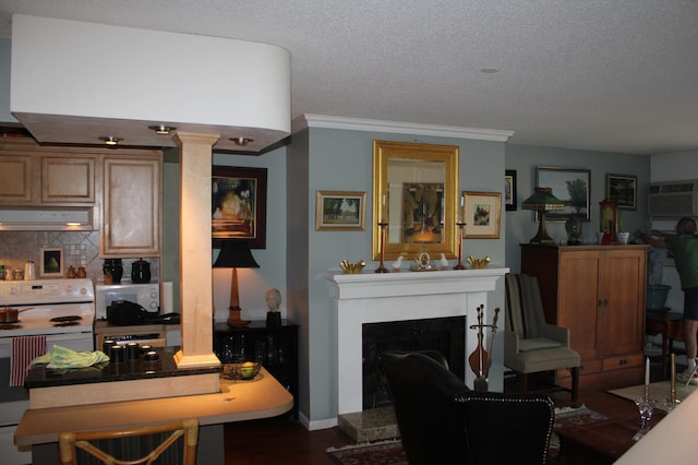 living room with decorative columns, a textured ceiling, baseboards, a fireplace with raised hearth, and ornamental molding