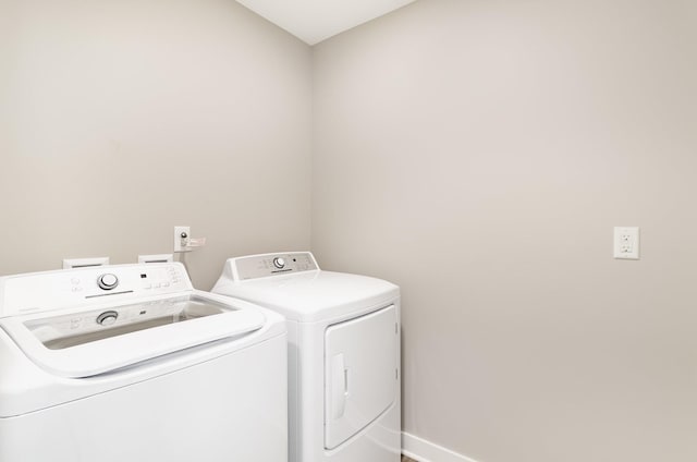 washroom with baseboards, laundry area, and independent washer and dryer