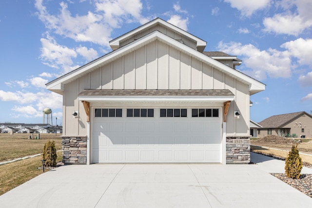 exterior space with stone siding, roof with shingles, board and batten siding, and concrete driveway