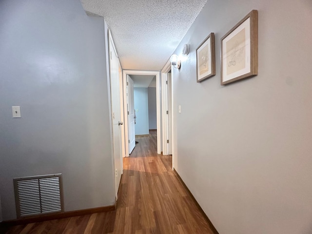4120 Parklawn Ave Unit 134, Edina, MN 55435 - hallway featuring visible vents, a textured ceiling, baseboards, and wood finished floors