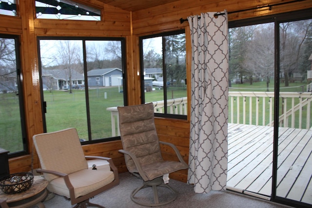 100 Park Rd, Staples, MN 56479 - sunroom with wood walls, lofted ceiling, a wooden deck, a residential view, and carpet flooring
